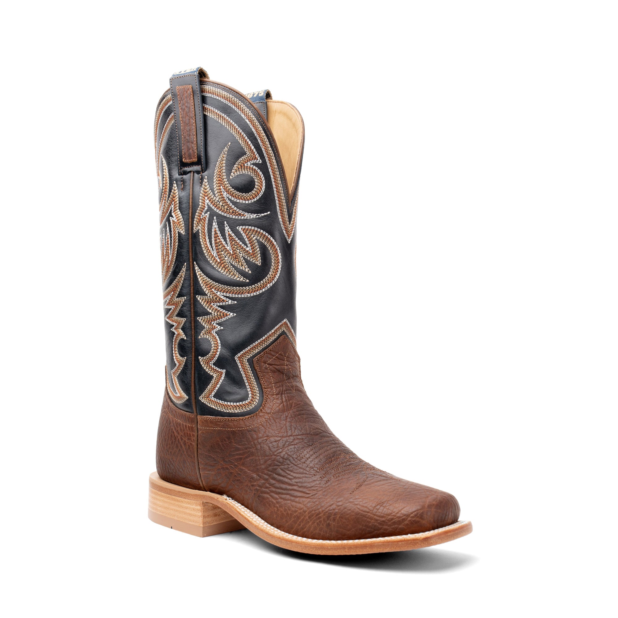 Brown and black cowboy boot with intricate stitching on a white background